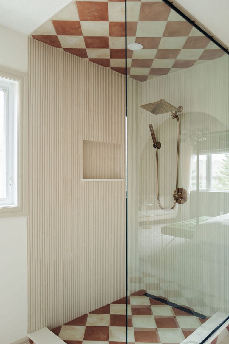 A glass shower with fluted wall tile, a built in niche and a checkered tile ceiling.